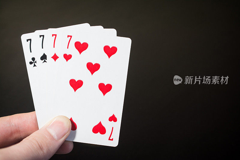 摘要:男子手持扑克牌四七孤立在黑色背景上带拷贝空间