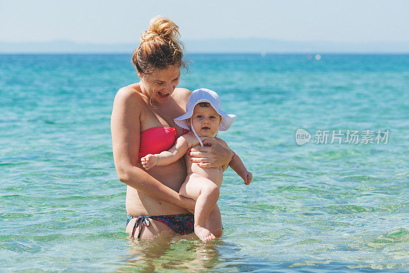 母亲和女婴在夏天的海水里