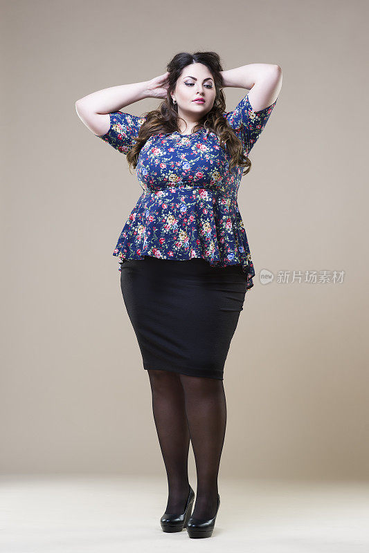 加码时装模特在休闲服装，肥胖的女人在米色工作室背景，超重的女性身体