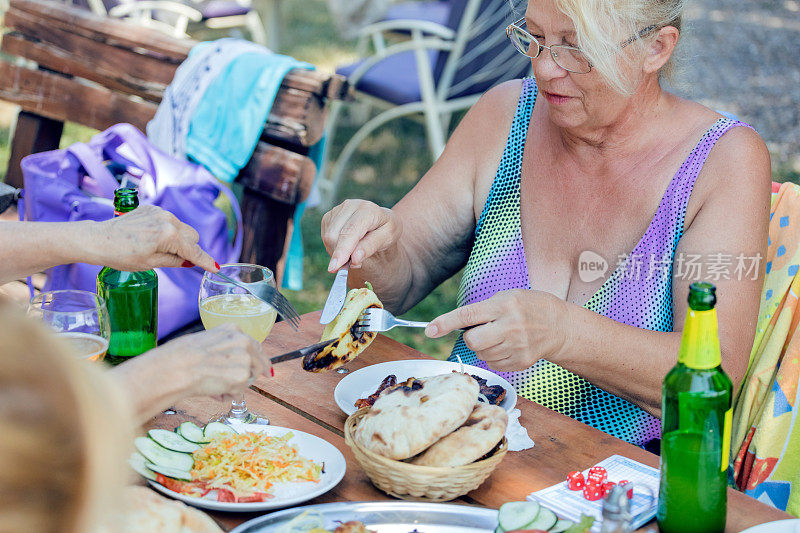 老年妇女在户外吃午餐