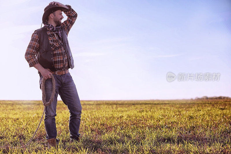 日落时分，牛仔站在田野里