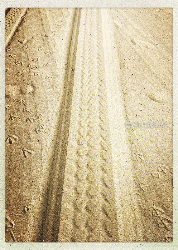 沙地上的轮胎印和脚印