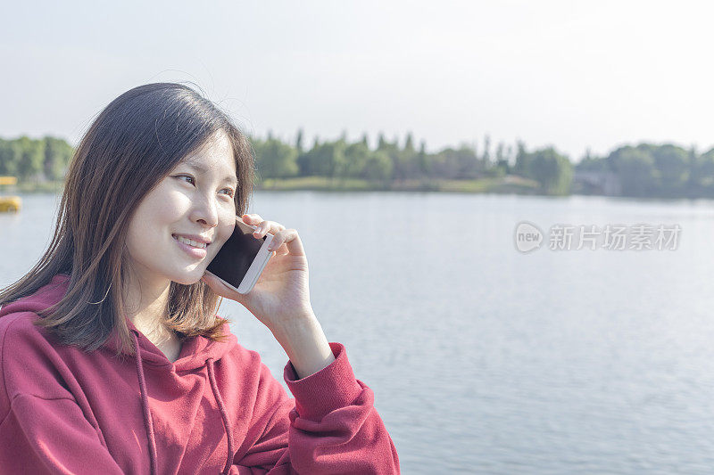 在湖边打电话的女人