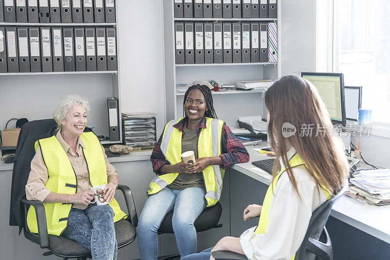 三个女人坐在办公室里喝咖啡休息