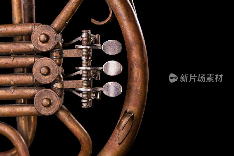 古董青铜管，阀门，关键机械元素法国圆号，黑色背景。良好的模式，提示乐器。