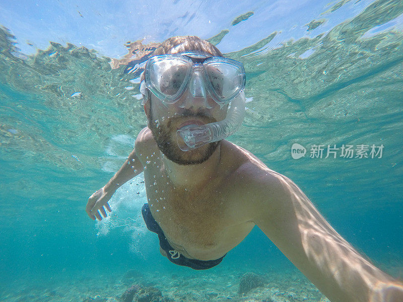 一名年轻人戴着潜水面罩在水下自拍