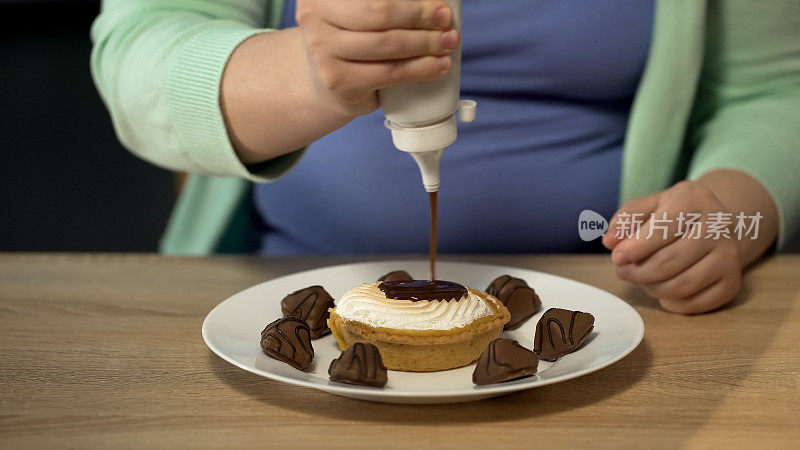 超重女性在糕点上浇上大量巧克力酱，导致肥胖