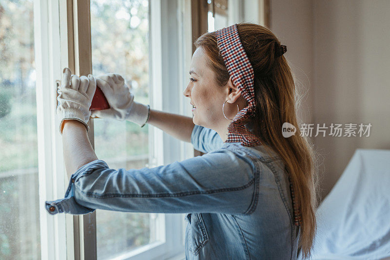 一个年轻女子在家里修窗户