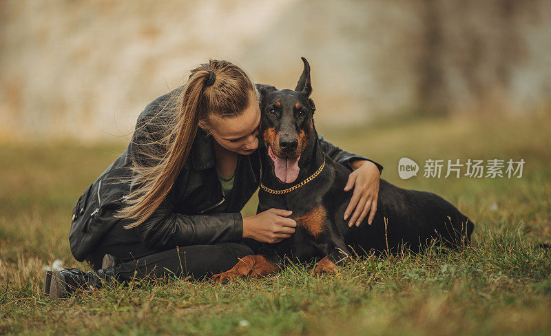 一个女人在玩她的杜宾犬