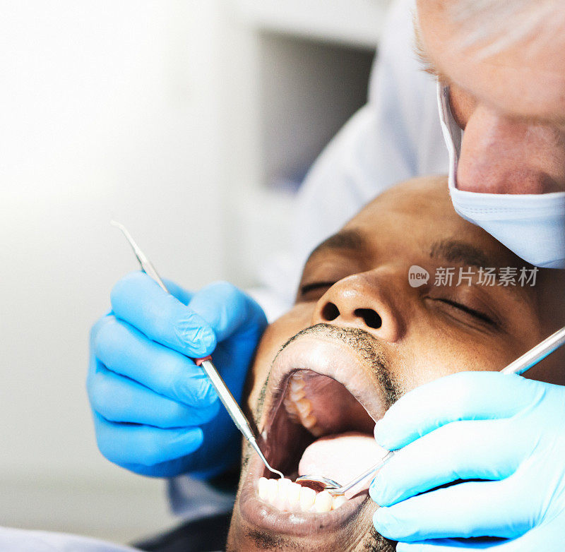 近距离看牙医检查病人的牙齿