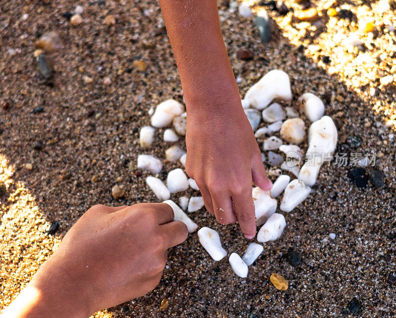 人的手用白色的石头做成心形
