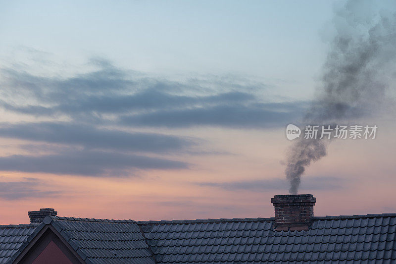 烟囱里冒着烟，夕阳下的天空