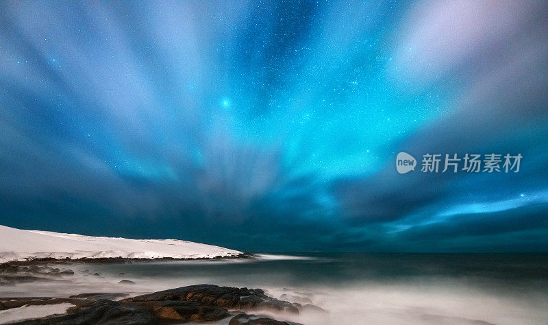 神奇的北极光。俄罗斯捷里别尔卡的北极光。星空，极地的光和云。夜冬山水以极光，海与石在模糊的水，雪山。旅行