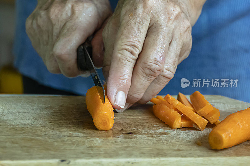 妇女在厨房切胡萝卜