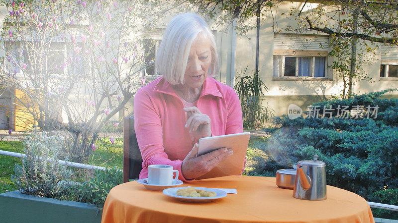 人们喜欢现代科技。一位老太太坐在咖啡厅里，用平板电脑看每天的新闻