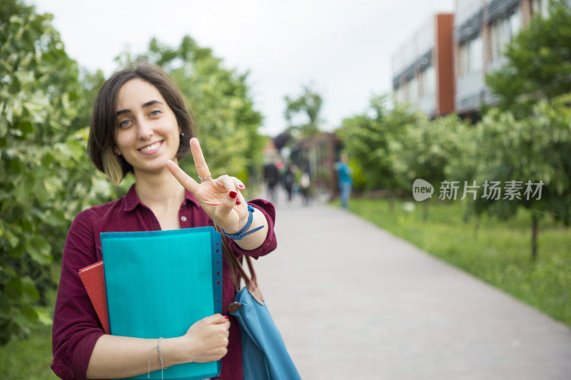 美丽的女学生在校园展示和平标志