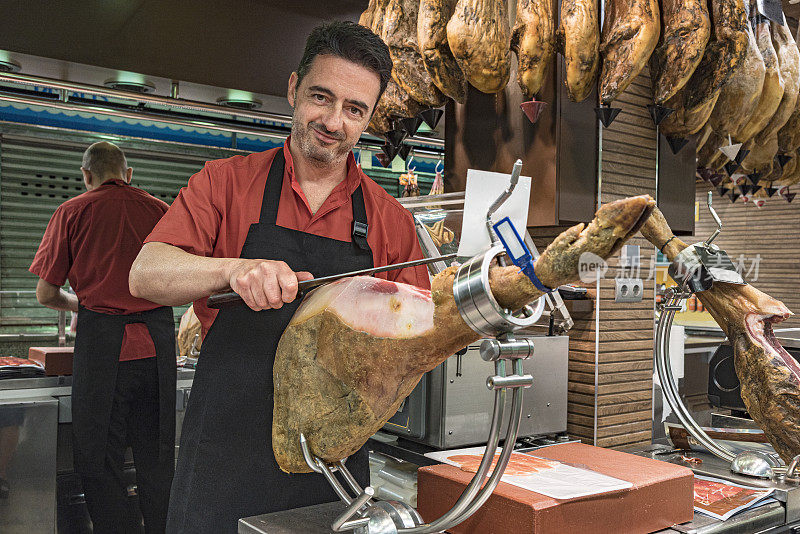 2019年9月8日，西班牙马德里，火腿屠夫用特制刀具将西班牙塞拉诺火腿切成薄片。