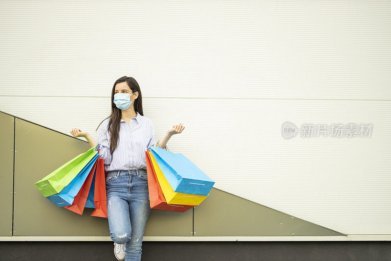 女人戴着保护面罩和购物