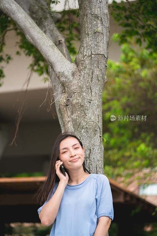 在户外使用智能手机的亚洲年轻女性