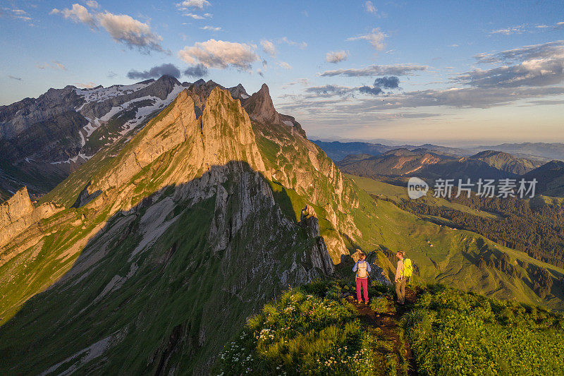 徒步旅行者从山顶看日落的无人机视图