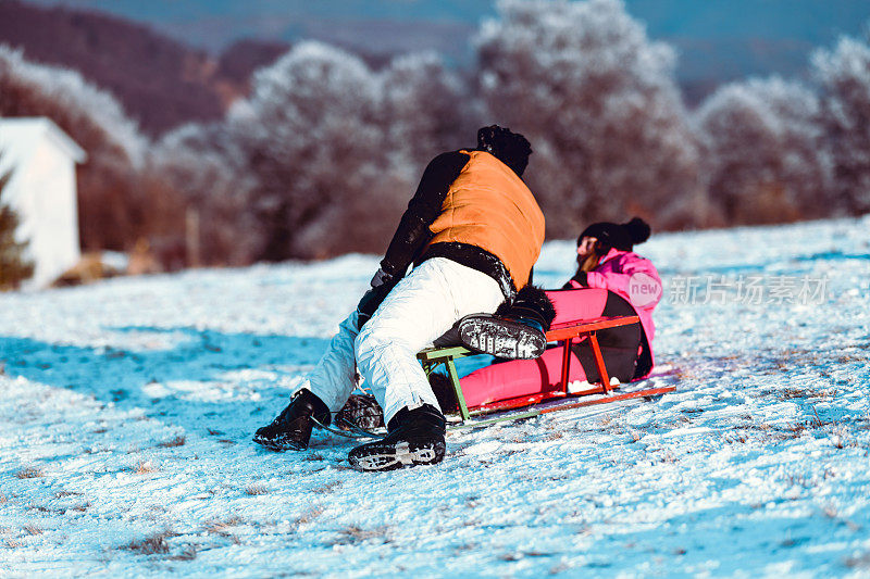 兄弟姐妹在雪山上滑着雪橇