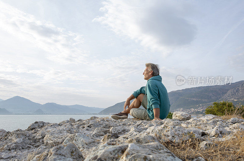 早晨，徒步旅行者在多岩石的海岸线上放松