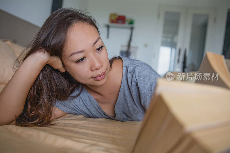 孤独的中国女人在自我隔离期间看书