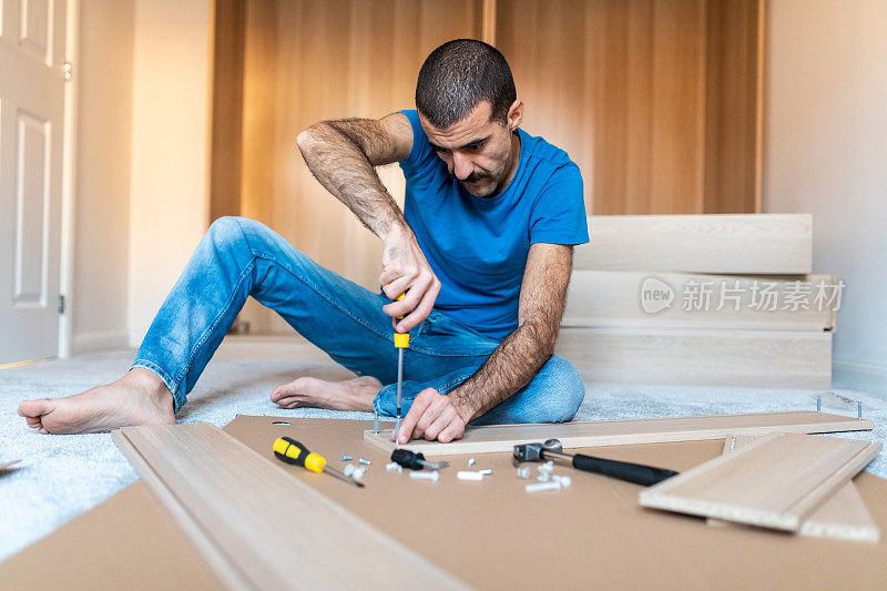 男人在家里组装家具，在新家DIY工作