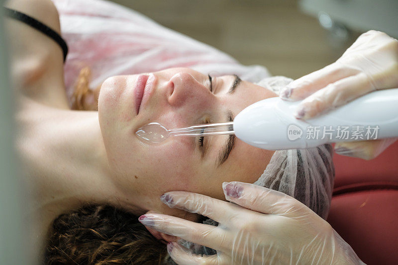 美容师对面部皮肤进行微电流治疗