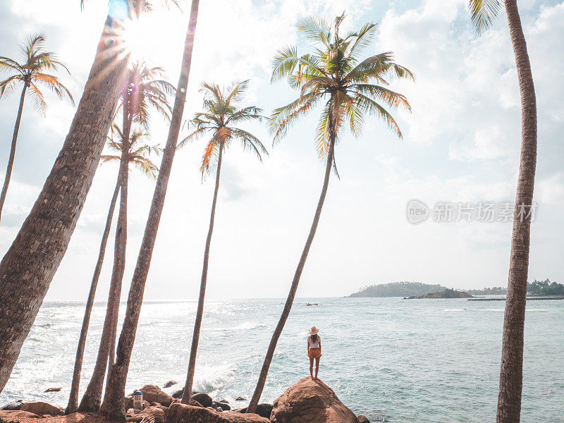 女人凝视着岩石上的海景