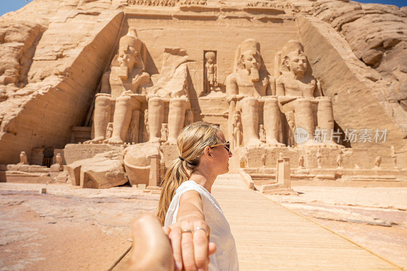 一对夫妇在埃及旅行，他们手牵着手跟随对方