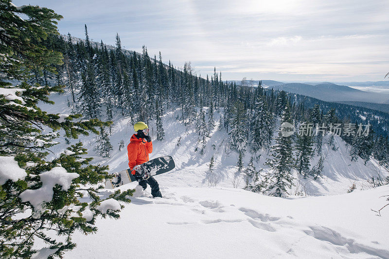 滑雪板自由骑手步行滑雪旅游在森林，野生山区，冬季阳光灿烂的一天