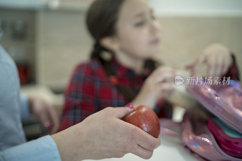 妈妈和她的女儿在为学校准备午餐