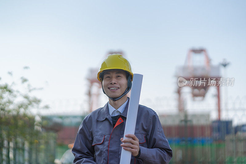 一位亚洲男工程师拿着图纸