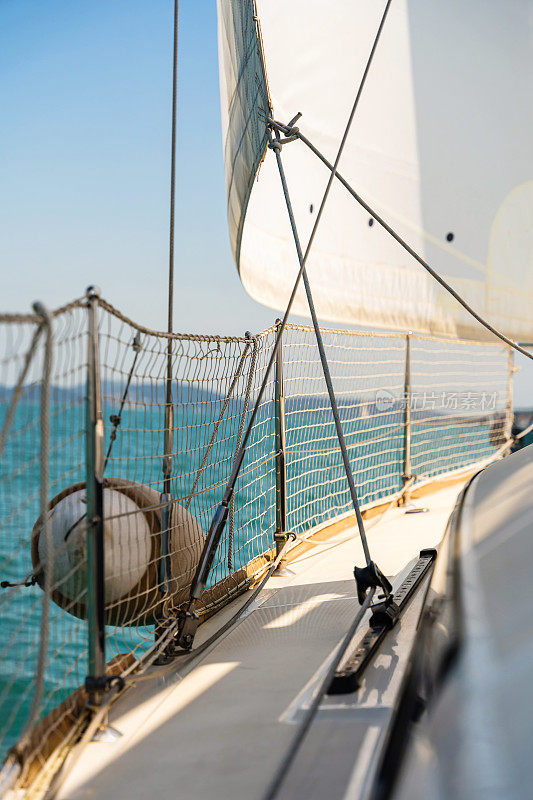 在一个阳光明媚的夏日，一艘豪华游艇的侧甲板景色。专注于绳子的细节，