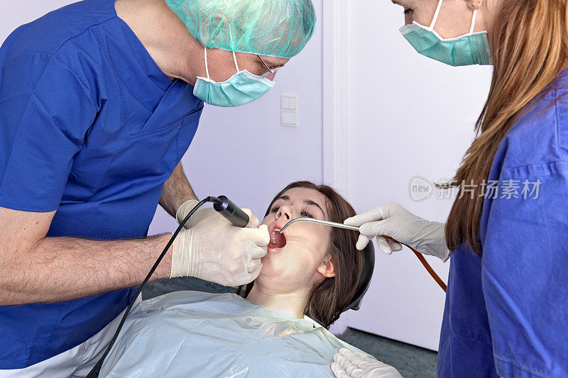 牙医在牙齿上钻孔。