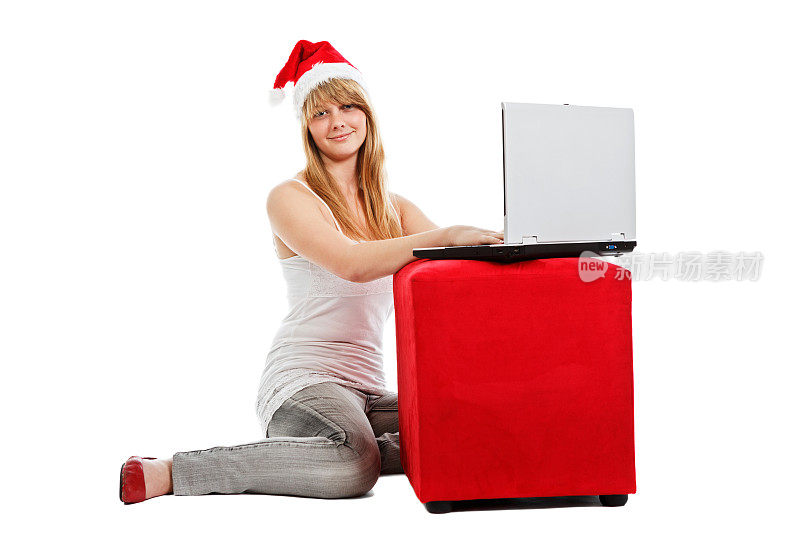 现代圣诞:微笑的少女在笔记本电脑上给圣诞老人写信