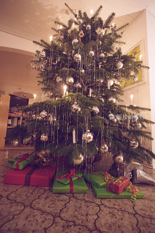 美丽的圣诞树与银色装饰和下面的礼物