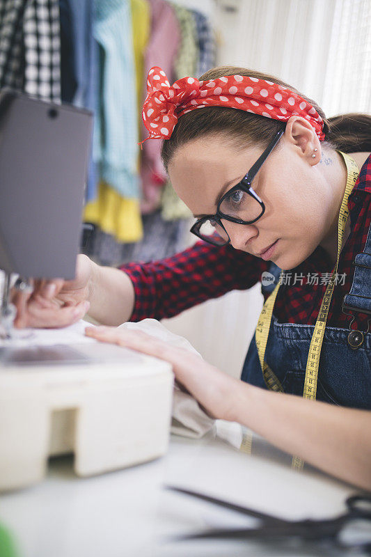 裁缝为工作调整缝纫机。