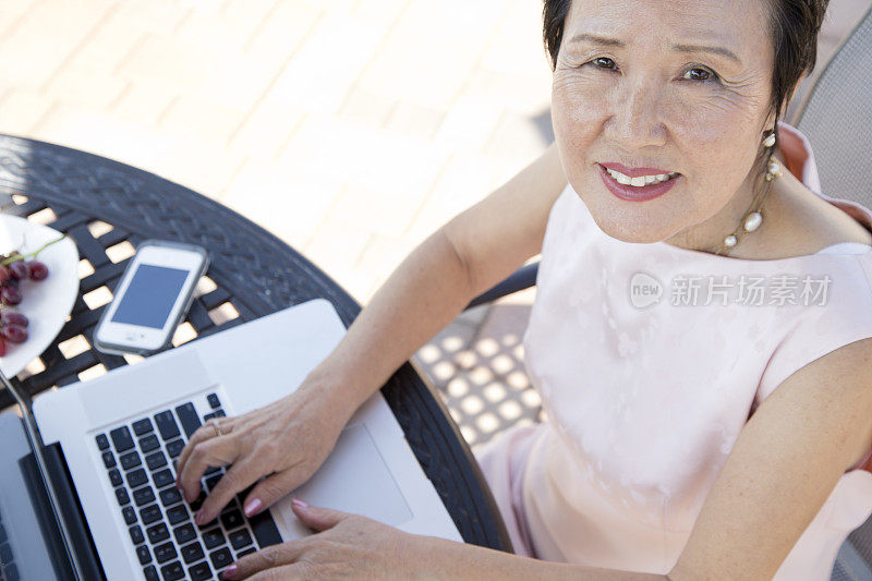 退休的亚洲资深女性在笔记本电脑上