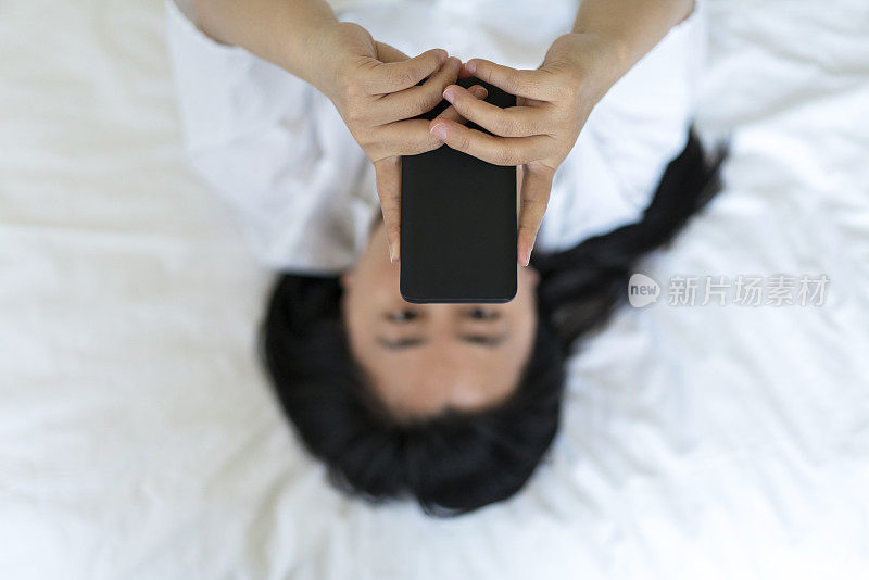 女孩在床上看手机