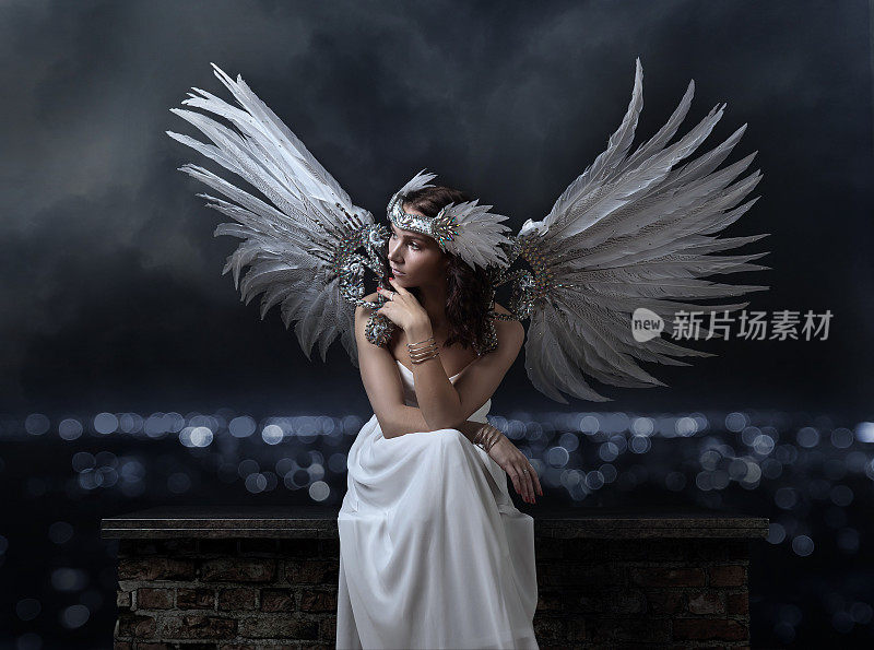 穿着白衣，长着天使翅膀的美丽女人