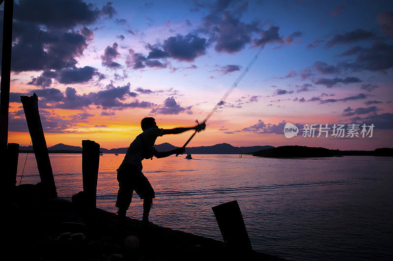 一名男子在泰国的一个码头钓鱼