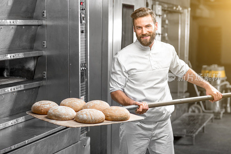 面包师从烤箱中拿出烤荞麦面包