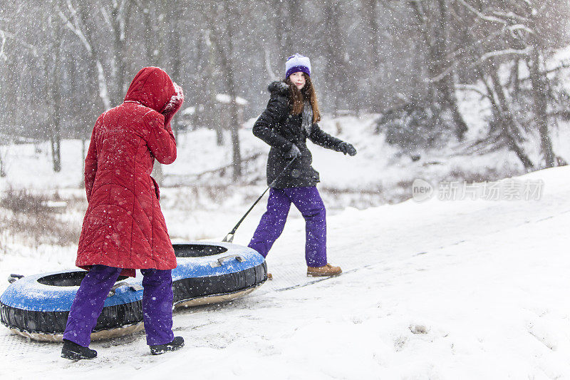 Snowtubing。两个女孩要去山顶