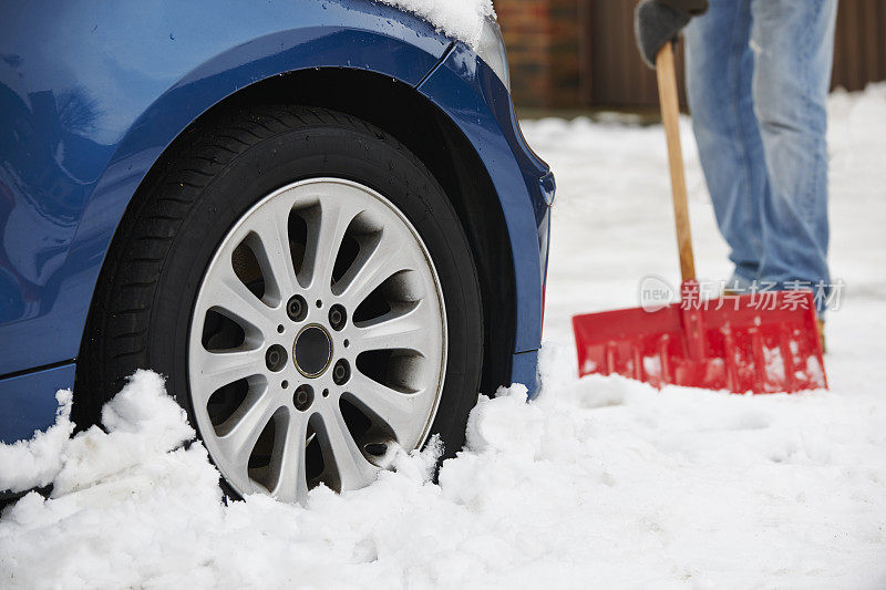 司机从雪中挖掘汽车