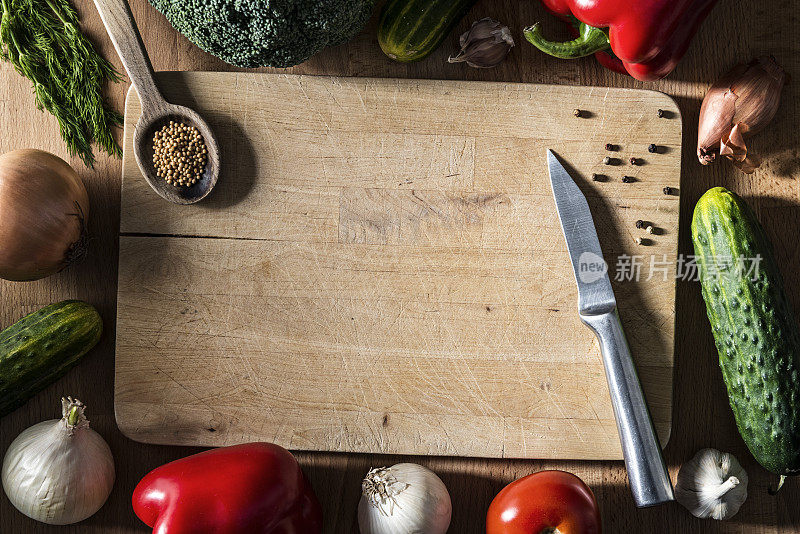 许多不同的蔬菜，香料，刀，匙在木砧板上