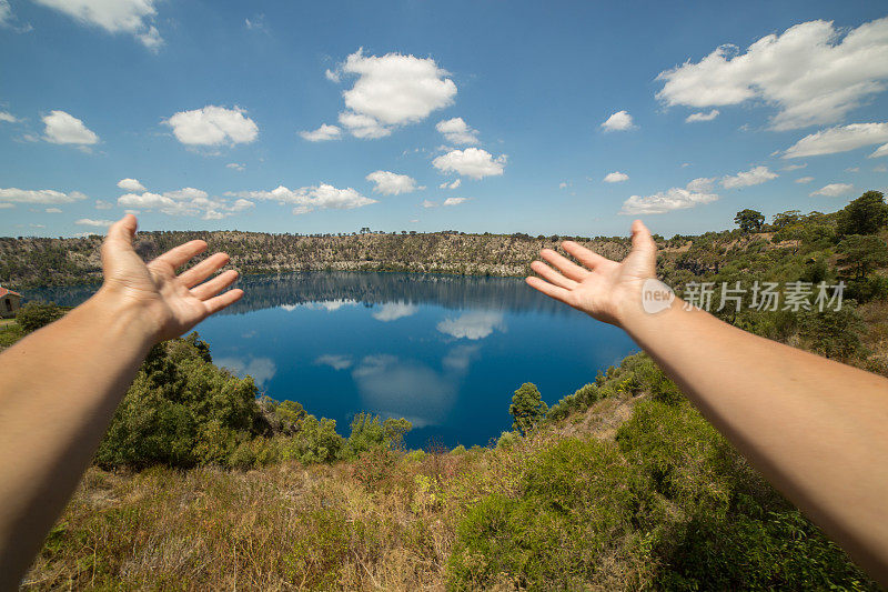 女人的手臂伸向澳大利亚的蓝色湖
