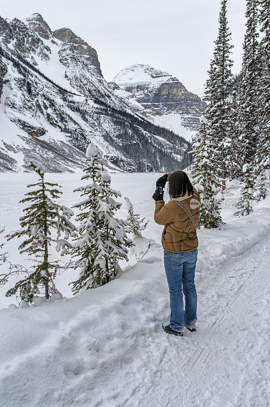 一个女人在雪山边拍照