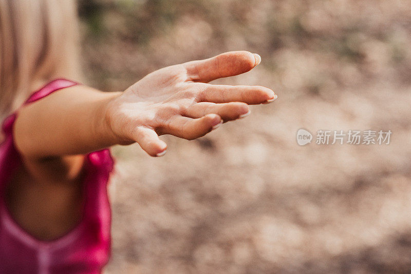 瑜伽女人伸出她的手臂集中在手上